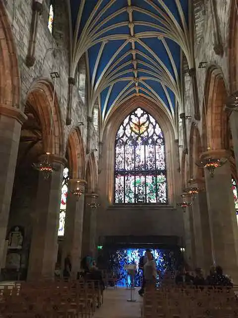 An interior shot of St. Giles Cathedral, focusing on a stained glass window.