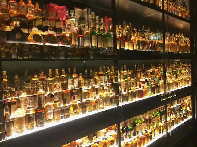 Shelves lamp-packed with bottles of Scotch