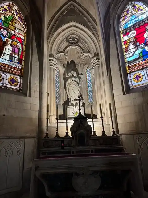 Sculpture and stained glass windows behind the altar