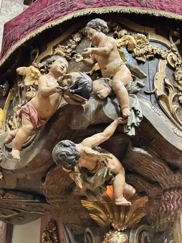 Close-up of three cherubs and a head on the pulpit