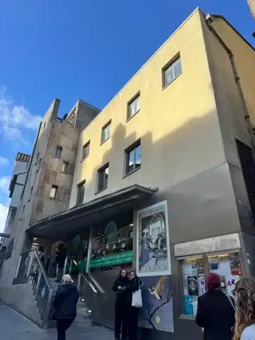 Picture of a mostly like yellow building, with a short set of stairs up to the main entrance of the Scottish Storytelling Centre